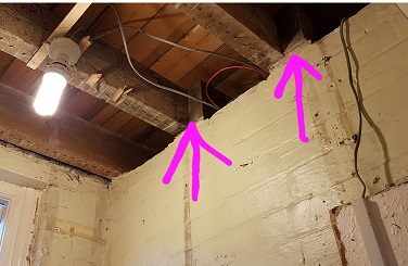 View from inside loo showing joists resting on wall.