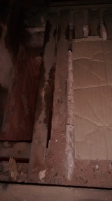 From loft looking down with chimney on left and external wall at top of photo