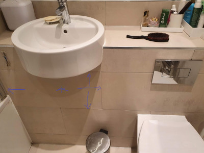 Outside of the tiling, the one that was sealed in with silicon rather than grout is marked.